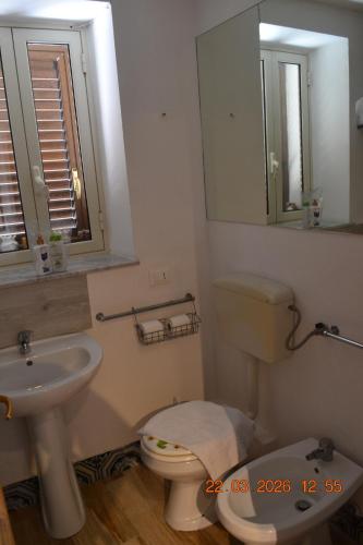 a bathroom with a toilet and a sink and a mirror at Loft le Due Effe al Capo in Palermo