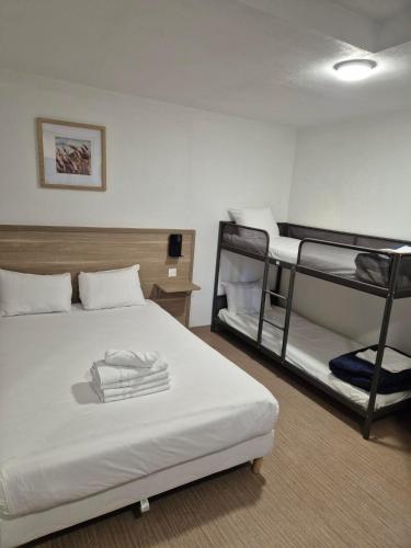 a bedroom with two bunk beds with white sheets at Class'eco Charleroi in Charleroi