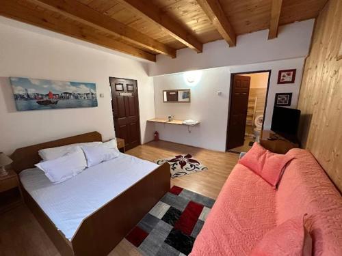 a bedroom with a bed and a desk in it at Plaiul Carpatin in Fundăţica