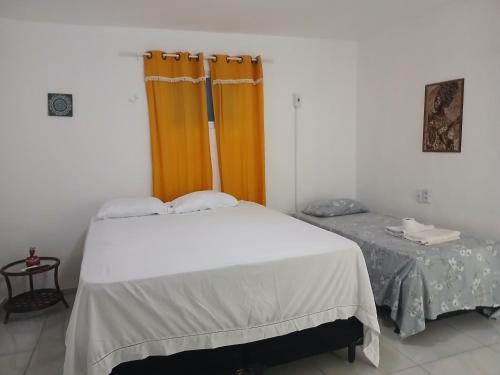 a bedroom with a white bed and a window at Pé na praia - Barraca da Márcia in Paracuru