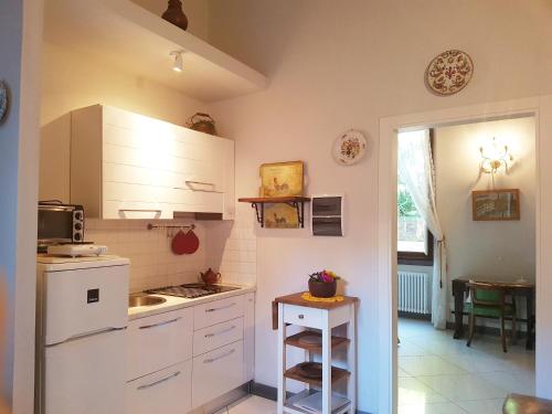 uma pequena cozinha com armários brancos e um lavatório em Peacefull in Duomo em Florença