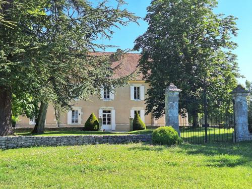 a house with a fence and trees in front of it at Domaine et Manoir du Picaud in Monestier