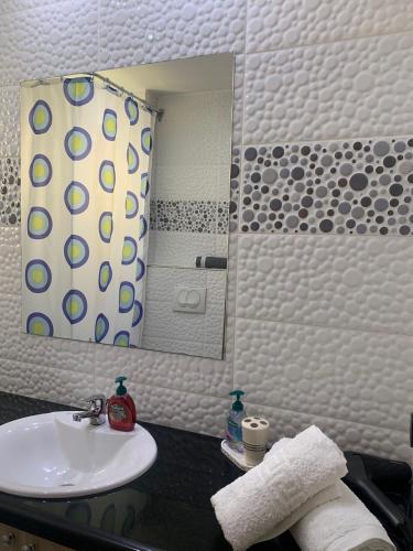 a bathroom with a sink and a mirror at Golem Central Stay in Golem