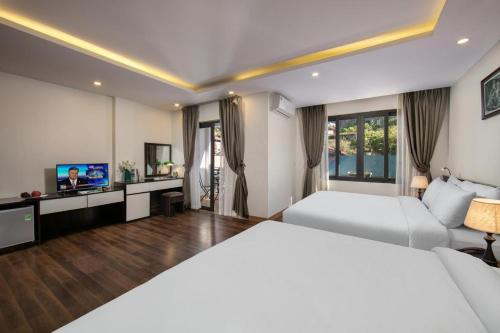 a hotel room with two beds and a flat screen tv at Hotel Del Couple Sapa in Sapa