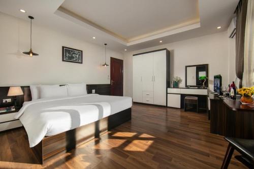 a bedroom with a large white bed and a desk at Hotel Del Couple Sapa in Sapa