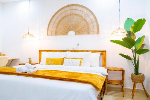 a bedroom with a large bed with a yellow blanket at Suite Kimia - Chic T2, Rue Des Jardins, Cocody, Vallon, Abidjan in Abidjan
