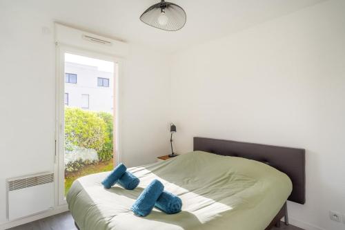 a bedroom with a bed with blue pillows on it at Le repere du golfe in Vannes