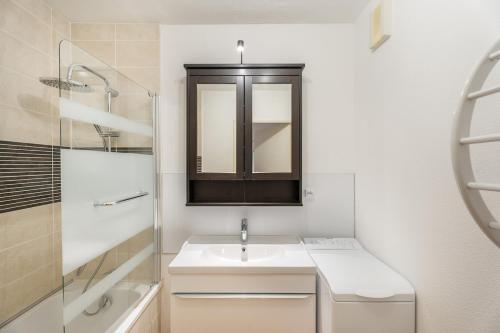 a white bathroom with a sink and a mirror at Le repere du golfe in Vannes