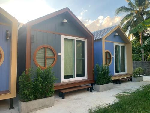 a tiny house with a round window and two plants at Homni Living Home in Ban Kohong