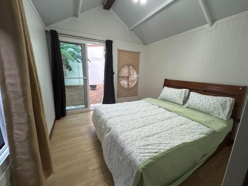 a bedroom with a bed and a large window at Homni Living Home in Ban Kohong