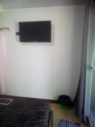 a bedroom with a flat screen tv on the wall at Homni Living Home in Ban Kohong
