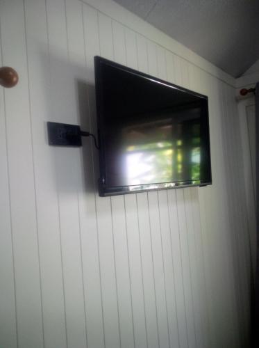 a flat screen tv hanging on a wall at Homni Living Home in Ban Kohong
