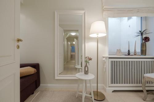 a room with a mirror and a table and a lamp at Appartement Lycka in Keitum