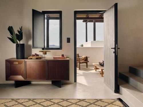 a living room with a wooden cabinet and a mirror at ananea Mykonos - Adults Only in Ornos