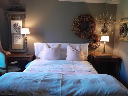 a bedroom with a bed with blue sheets and pillows at la maison de Royer in Meuzac