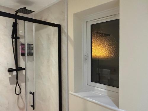 a shower in a bathroom with a window at StaxBnB in London