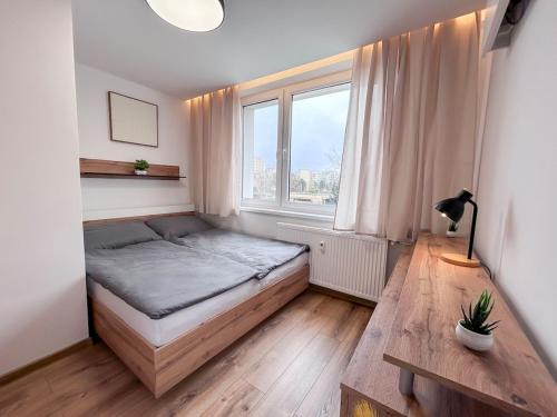 a small bedroom with a bed and a window at Green Oasis Apartment in Myslava