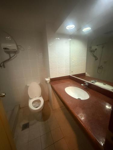 a bathroom with a toilet and a sink at W Express Hotel in Cebu City