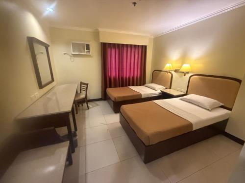 a hotel room with two beds and a desk at W Express Hotel in Cebu City