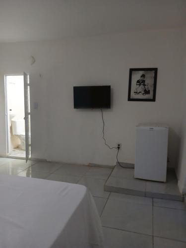 a white room with a flat screen tv on a wall at Pé na praia - Barraca da Márcia in Paracuru