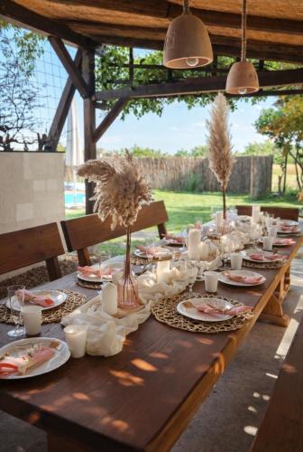a long wooden table with plates of food on it at Kuća za odmor Petra in Erdut