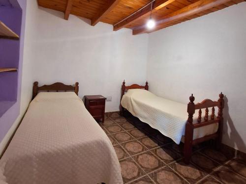 a bedroom with two beds in a room at Hostal Nahiara, Iruya in Iruya