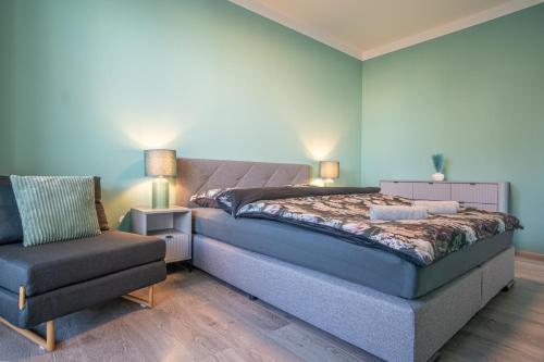a bedroom with a bed and a chair at Apartmán Nová Dragounská in Klatovy