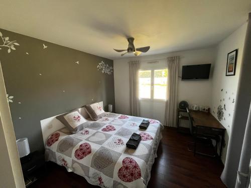 a bedroom with a bed and a ceiling fan at Ô Pas-Sage - Maison d'Hôtes in Gousse