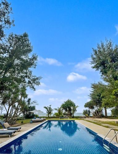 a swimming pool in a resort with trees at Sirinary Villa - Natai Phangnga in Ban Na Tai