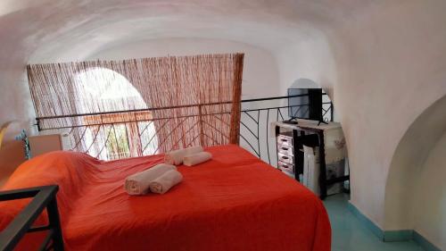 a bedroom with a red bed with towels on it at La Gemma Amalfitana in Vietri sul Mare