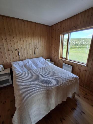 a bedroom with a white bed and a window at Mid-Sel mountain view lodge in Hella