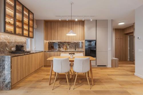 a kitchen and dining room with a table and chairs at Honey Oak Residence in Oradea