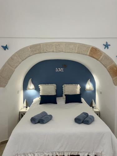 a large bed with two blue pillows on it at Mamy Sweet Loft in Polignano a Mare