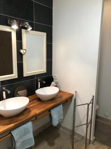 a bathroom with two sinks on a wooden counter at Chai Léopold in Surgères