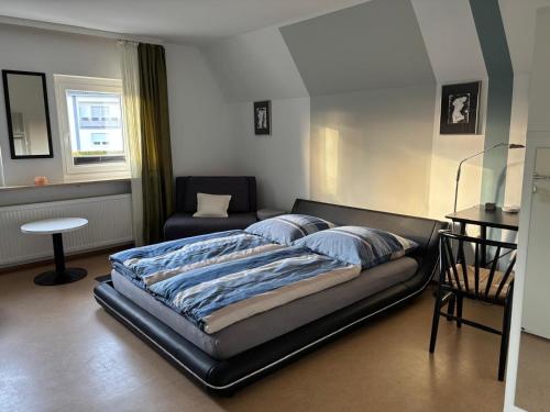 a bedroom with a bed and a couch and a chair at Villa Sonnenschein im Zentrum Bad Stebens nahe der Therme in Bad Steben