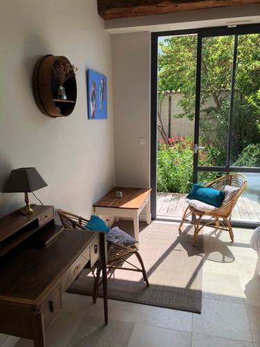 a living room with a table and chairs and a window at Chai Léopold in Surgères