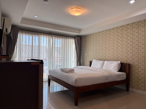 a bedroom with a bed and a large window at Sea Residence Hua Hin 45 in Hua Hin