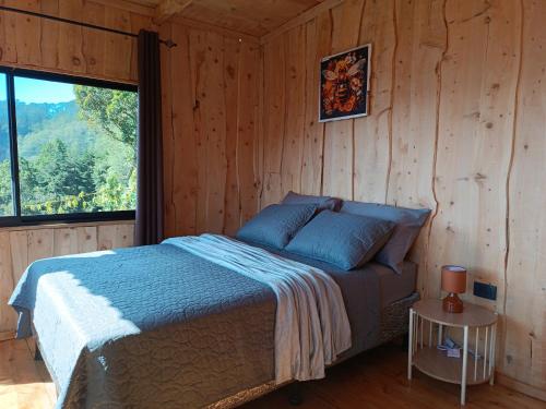a bedroom with a bed in a wooden cabin at Calcopirita Stay House in Rivas