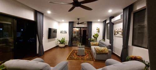 a living room with white chairs and a ceiling fan at Bayon Country Villa in Phumĭ Trás Treăng