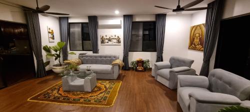 a living room with couches chairs and a table at Bayon Country Villa in Phumĭ Trás Treăng