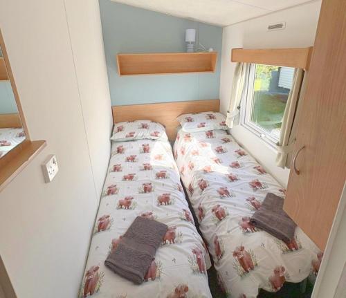a bedroom with two beds in a small room at 609 Sycamore Forest in Newquay