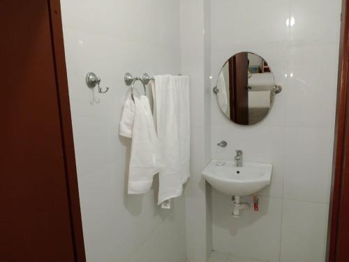 a white bathroom with a sink and a mirror at Rinconcito Veracruzano in Veracruz