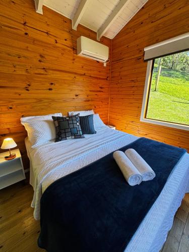 a large bed in a room with a window at Quinta Terra Sagrada in Urubici