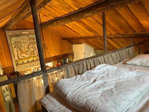 a bed in a room with a wooden ceiling at Stuga med havsutsikt in Strömstad