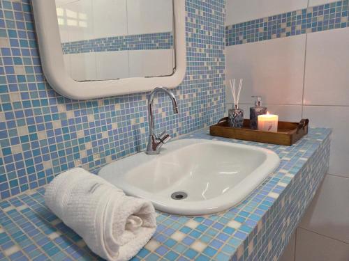 a bathroom with a sink and a mirror and a towel at Flat 02 Carvalhos de Aldeia in Recife