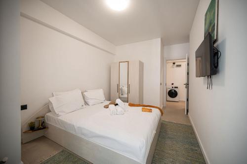 a bedroom with a white bed with two stuffed animals on it at Sim Seaside Odyssey in Mamaia Sat/Năvodari