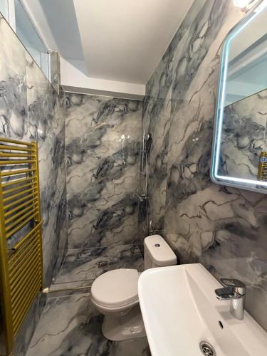 a bathroom with a white toilet and a sink at Vila Chiara in Makarska