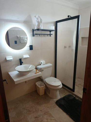 ein Badezimmer mit Toilette, Waschbecken und Spiegel in der Unterkunft Hotel CEO Group in Campeche