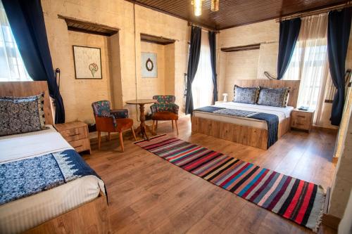a bedroom with two beds and a table at Levissi boutique hotel in Gaziantep