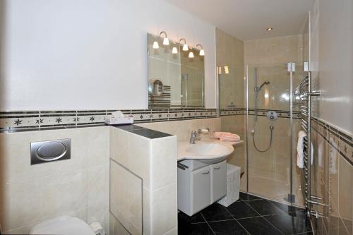 a bathroom with a sink and a shower and a toilet at Appartement 4You in Schladming